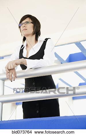 Picture - Hispanic businesswoman standing in office lobby. Fotosearch