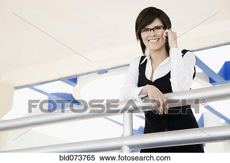 Hispanic businesswoman standing in office lobby View Large Photo Image Stock Photography - Hispanic businesswoman standing in office lobby. Fotosearch