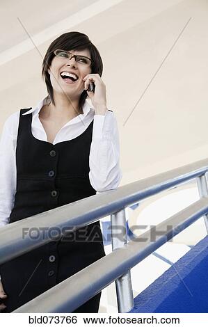 Stock Photograph - Hispanic businesswoman talking on cell phone. Fotosearch