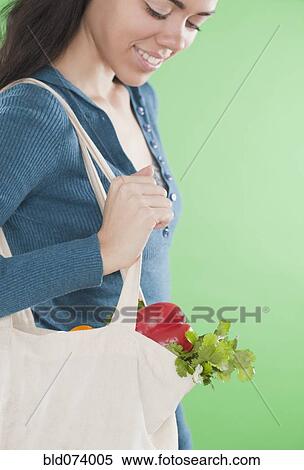 Hispanic woman carrying reusable bag of vegetables View Large Photo Image Stock Photography - Hispanic woman carrying reusable bag of vegetables. Fotosearch