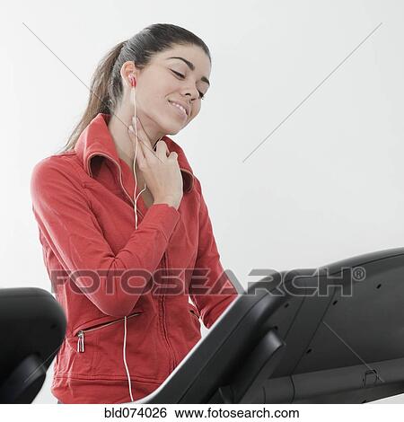 Stock Photograph - Hispanic woman checking pulse rate in health club. Fotosearch