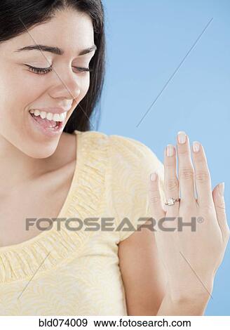 Stock Photo - Hispanic woman displaying engagement ring. Fotosearch