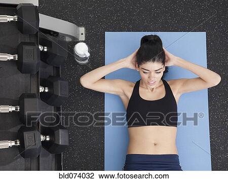 Hispanic woman doing sit-ups in health club View Large Photo Image Stock Image - Hispanic woman doing sit-ups in health club. Fotosearch