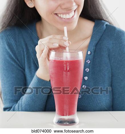 Stock Image - Hispanic woman drinking fruit smoothie. Fotosearch