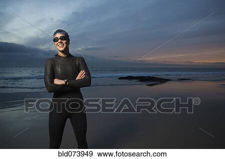 Hispanic woman in wetsuit on beach View Large Photo Image Stock Photo - Hispanic woman in wetsuit on beach. Fotosearch