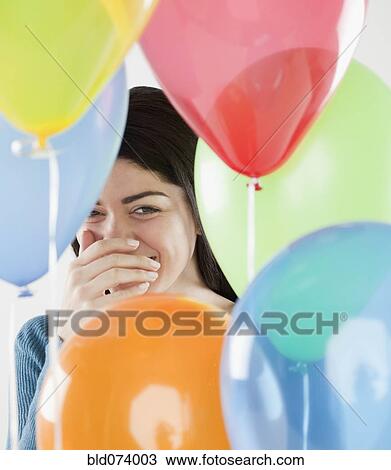 Hispanic woman laughing behind balloons View Large Photo Image Stock Image - Hispanic woman laughing behind balloons. Fotosearch
