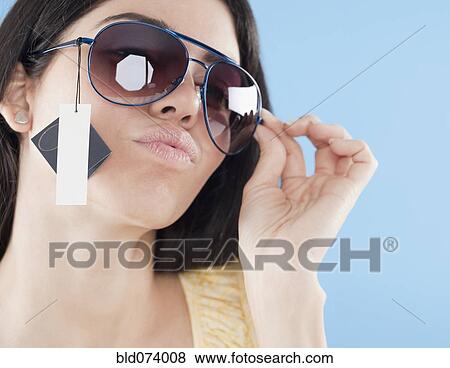 Stock Photo - Hispanic woman trying on sunglasses. Fotosearch
