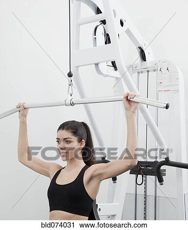 Hispanic woman using weight machine in health club View Large Photo Image Stock Image - Hispanic woman using weight machine in health club. Fotosearch