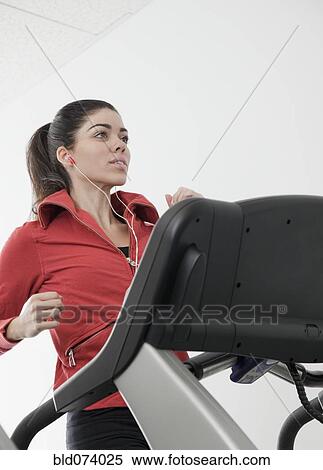 Stock Photography - Hispanic woman walking on treadmill. Fotosearch
