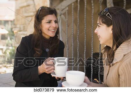 Stock Photo - Middle Eastern mother and daughter drinking coffee. Fotosearch