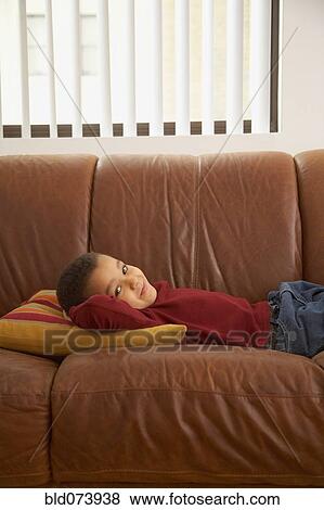 Mixed race boy laying on couch View Large Photo Image Stock Photo - Mixed race boy laying on couch. Fotosearch