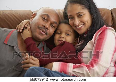 Mixed race boy snuggling on couch with parents View Large Photo Image Stock Image - Mixed race boy snuggling on couch with parents. Fotosearch