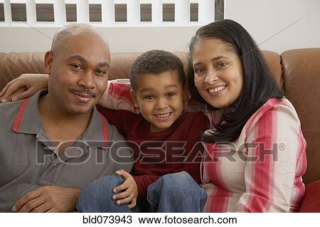 Mixed race boy snuggling on couch with parents View Large Photo Image Stock Image - Mixed race boy snuggling on couch with parents. Fotosearch