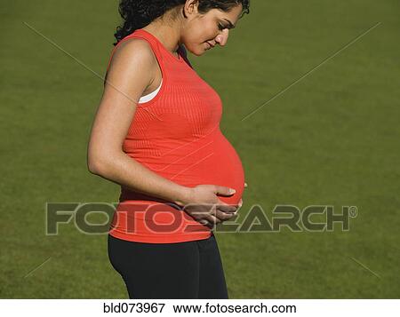 Pregnant Middle Eastern woman looking down at stomach View Large Photo Image Stock Photo - Pregnant Middle Eastern woman looking down at stomach. Fotosearch