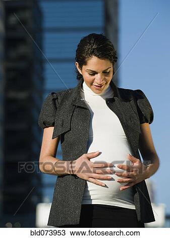 Pregnant Middle Eastern woman rubbing stomach View Large Photo Image Stock Image - Pregnant Middle Eastern woman rubbing stomach. Fotosearch