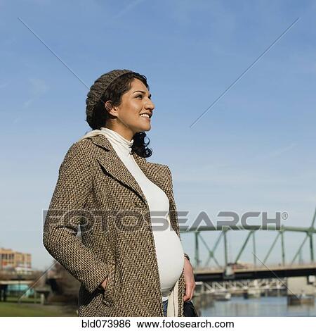 Pregnant Middle Eastern woman standing at waterfront View Large Photo Image Stock Photograph - Pregnant Middle Eastern woman standing at waterfront. Fotosearch