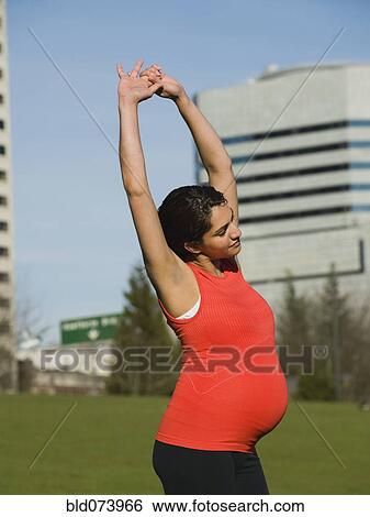 Pregnant Middle Eastern woman stretching View Large Photo Image Stock Photograph - Pregnant Middle Eastern woman stretching. Fotosearch