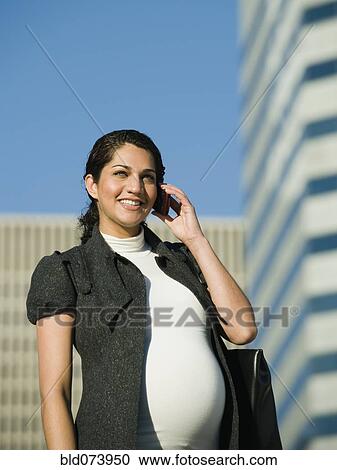 Pregnant Middle Eastern woman using cell phone View Large Photo Image Stock Image - Pregnant Middle Eastern woman using cell phone. Fotosearch