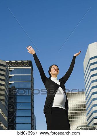 Stock Photo - Pregnant Middle Eastern woman with arms raised outdoors. Fotosearch