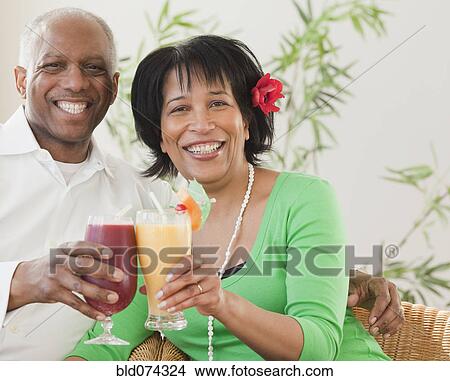 Picture - African couple drinking exotic frozen cocktails. Fotosearch