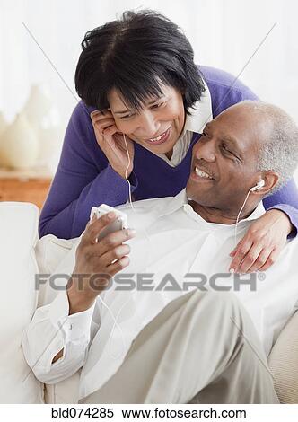 Stock Photography - African couple listening to mp3 player. Fotosearch