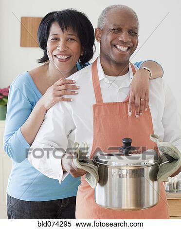 Stock Photography - African couple preparing dinner. Fotosearch