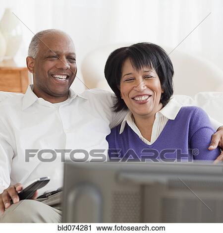 Stock Image - African couple watching television. Fotosearch