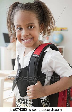 Stock Image - African girl carrying backpack. Fotosearch