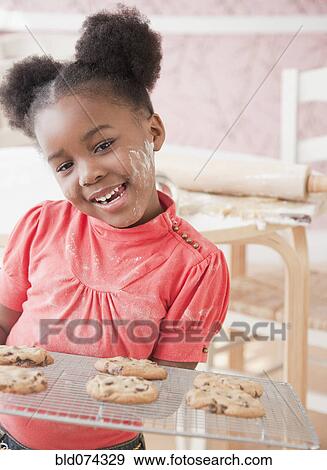 African girl holding fresh baked cookies View Large Photo Image Stock Photo - African girl holding fresh baked cookies. Fotosearch