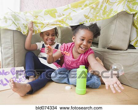 Picture - African girls blowing bubbles. Fotosearch