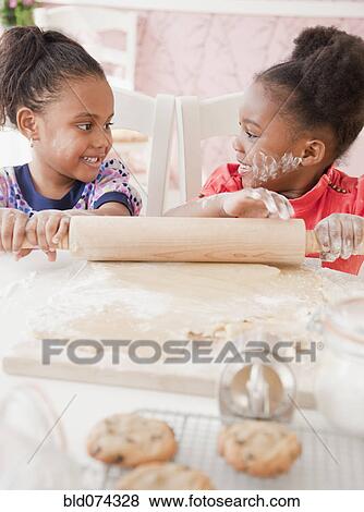 Stock Photo - African girls making cookies. Fotosearch