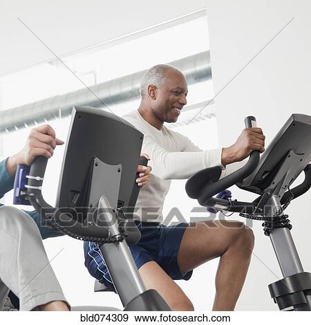 Stock Photo - African man exercise in health club. Fotosearch