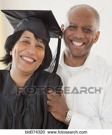 Stock Image - African woman graduate with husband. Fotosearch