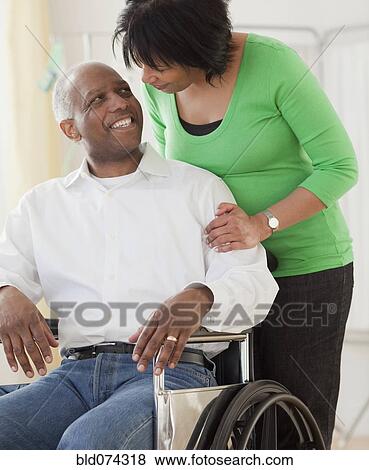 African woman pushing husband in wheelchair View Large Photo Image Stock Photo - African woman pushing husband in wheelchair. Fotosearch
