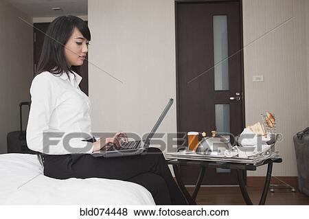 Stock Photo - Asian businesswoman working in hotel room. Fotosearch