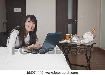 Asian businesswoman working in hotel room View Large Photo Image Stock Photo - Asian businesswoman working in hotel room. Fotosearch