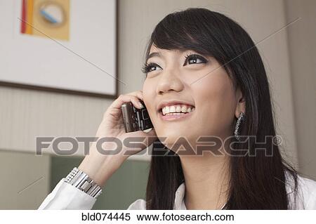 Stock Photography - Asian woman talking on cell phone. Fotosearch