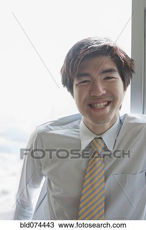 Stock Image - Chinese businessman smiling. Fotosearch