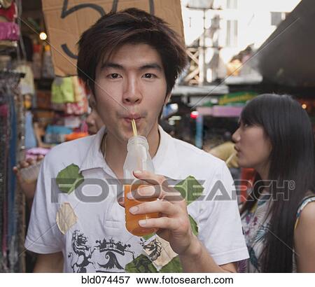 Stock Photo - Chinese man drinking juice. Fotosearch