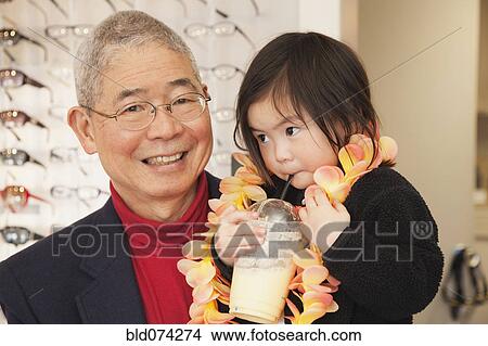 Picture - Chinese man holding granddaughter. Fotosearch