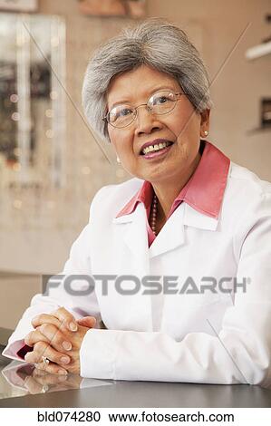 Stock Image - Chinese optician smiling. Fotosearch
