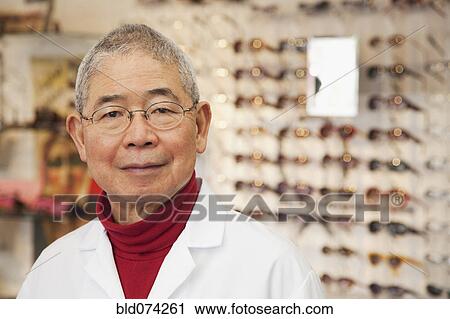 Stock Image - Chinese optician standing in store. Fotosearch
