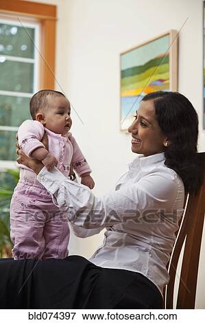 Stock Photo - Indian mother holding baby. Fotosearch