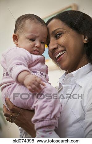 Stock Photo - Indian mother holding baby. Fotosearch