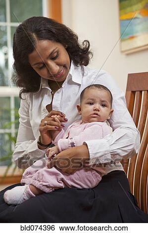 Stock Photograph - Indian mother holding baby. Fotosearch