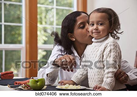Stock Photograph - Indian mother kissing daughter. Fotosearch