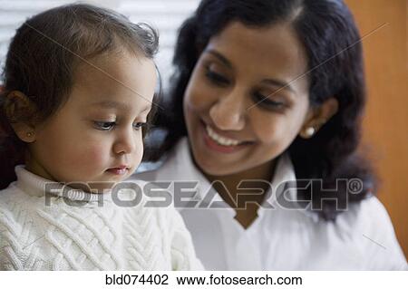 Indian woman smiling at daughter View Large Photo Image Stock Image - Indian woman smiling at daughter. Fotosearch