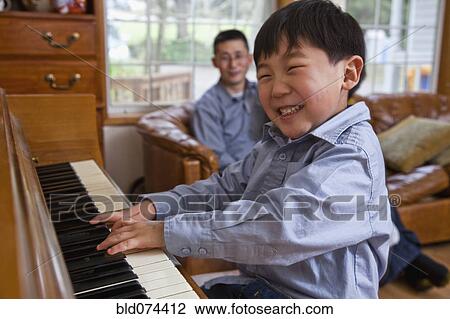 Stock Image - Korean boy playing piano. Fotosearch