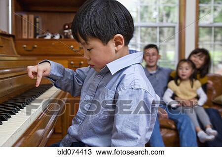 Stock Image - Korean boy playing piano. Fotosearch