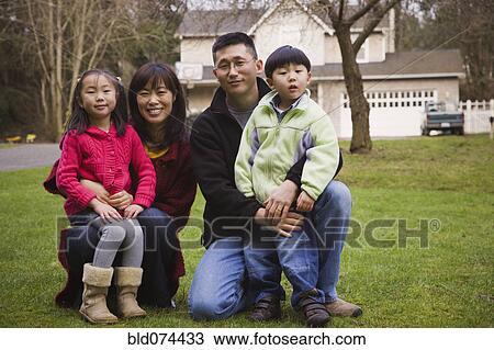 Stock Image - Korean family posing front yard. Fotosearch